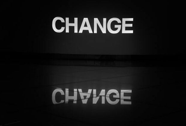 Das Wort Change in großen Lettern spiegelt sich auf einer Oberfläche