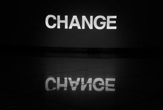 Das Wort Change in großen Lettern spiegelt sich auf einer Oberfläche